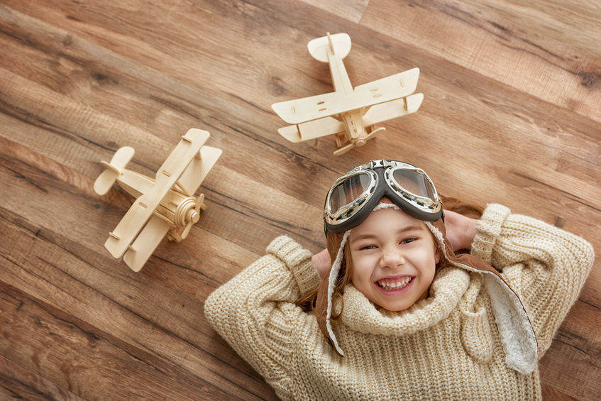 petite fille avec deux avions en bois